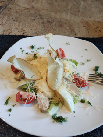 a caesar salad on a plate in a restaurantの写真素材