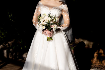 bride in a white wedding dress holds her wedding bouquet in her hands