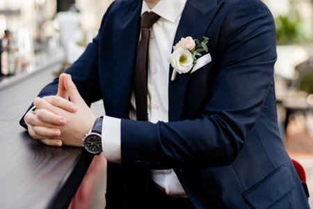 groom in a suit is sitting at the bar waiting for the bride at the weddingの写真素材