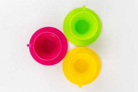 a multi-colored plastic cups and plates on a white background kitchen setの写真素材