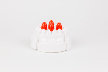 a plastic toy children's cake with white cream on a white backgroundの写真素材