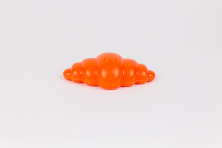 a plastic children's toy French croissant on a white backgroundの写真素材
