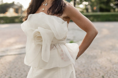 a bride in a white wedding dress in the park at sunsetの写真素材