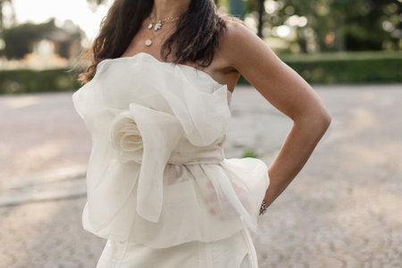 a bride in a white wedding dress in the park at sunsetの写真素材