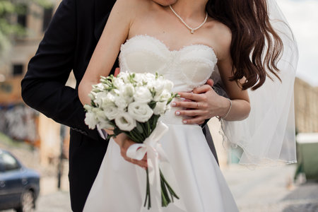 groom and the bride in a wedding dress together with a wedding bouquetの写真素材