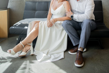groom and the bride are sitting together on the sofa at the weddingの写真素材