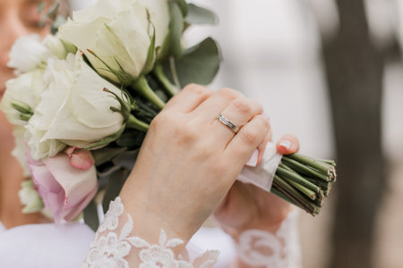 bride in a wedding dress holds a bouquet of flowers in her handsの写真素材