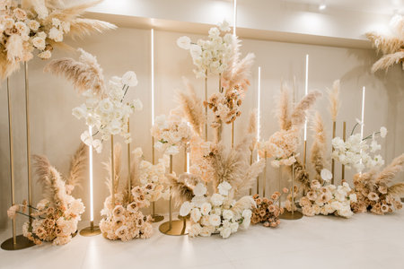a decorative wedding party indoor wall of flowers with yellow lightの写真素材