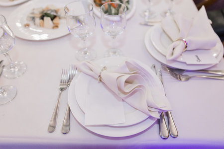 plate, knife and fork on a festive table in a restaurant at a weddingの写真素材