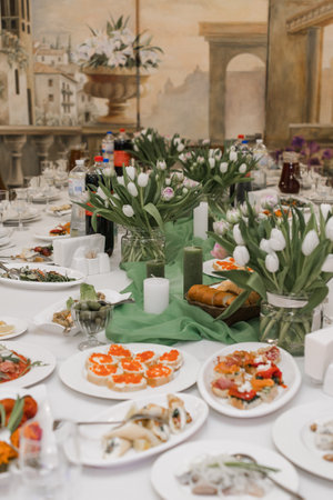 a wedding party banquet table with food and drinks for the birthdayの写真素材