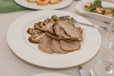 a meat cut on a plate on a festive table in a restaurantの写真素材