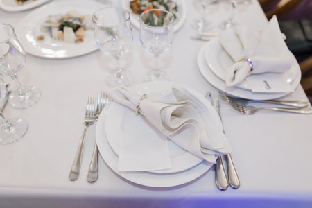 plate, knife and fork on a festive table in a restaurant at a weddingの写真素材