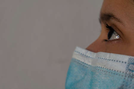 Left side of a young white woman's face with a facial maskの写真素材