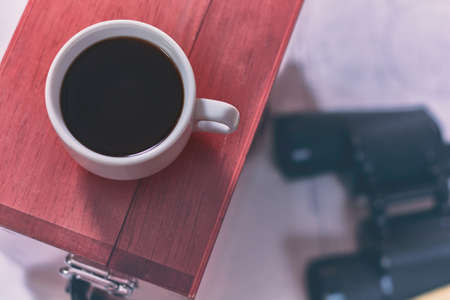 Background with cup of coffee and blurred binocular, pencil, marine sextant lying down on navigational chart.の写真素材