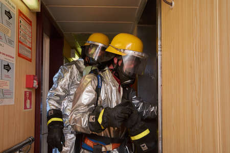 At sea - September 2018: International ship's crew performing monthly fire drill exercise onboard...