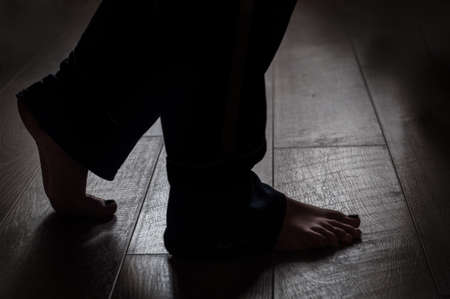 Barefoot legs on a warm wooden background. Fitness background. Healthy lifestyle. Warm floor concept. Sporty healthy female. Female body. Relax concept. Active indoor training.の写真素材