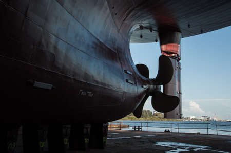 View of ship propeller and rudder in a dry dock background. Transportation industry. Freight transportation. Ship repair and maintenance concept.の写真素材