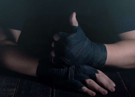 Hands of fighter in modern style on black background. Health care concept. Fitness muscular body....