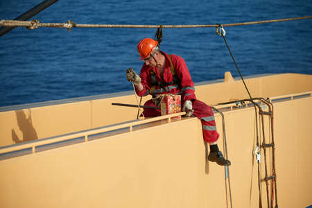 Atlantic Ocean, Open Sea - Circa March 2019: International Ships Crew Performing working aloft, crane painting onboard of an international merchant ship.のeditorial素材