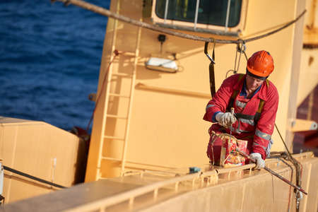 Atlantic Ocean, Open Sea - Circa March 2019: International Ships Crew Performing working aloft, crane painting onboard of an international merchant ship.のeditorial素材