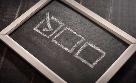 Blackboard with check boxes on chalk board. Hand writing. Dark background.