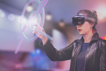 Portrait of young Caucasian woman using augmented and virtual reality with holographic hololens...
