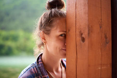 Beautiful happy smiling wet woman during rainy day staying near the lake in mountains. Lifestyle concept.の写真素材