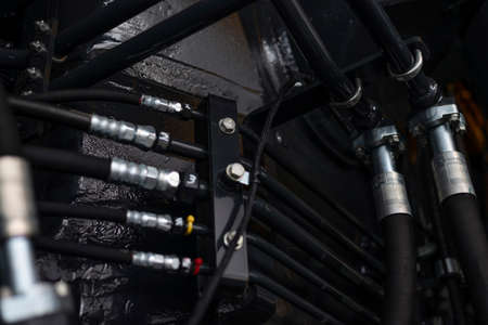 Close up view of hydraulic pipes of heavy industry machine. Low key. Hydraulic maintenance concept.の写真素材