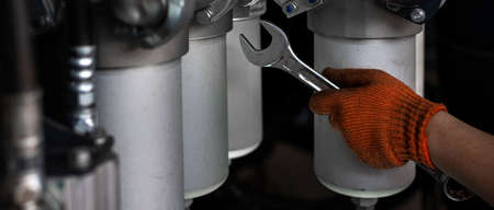 Banner with close up view of maintenance process of hydraulic pipes and oil filters of heavy...