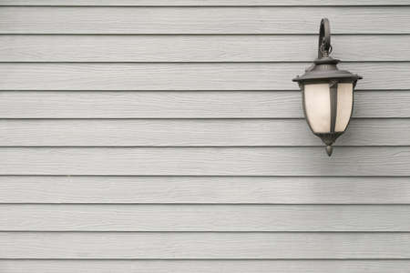 Vintage Antique Classic wall lamp on grey wood wall, for background with copyspace