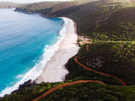 Aerial drone view of the coastal road that winds down to a quiet and remote bay in Albany, Australia.のeditorial素材