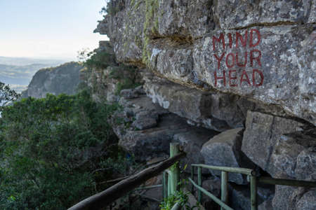 Mind Your Head painted on over-hanging rock found on steep hike in Oribi Gorge