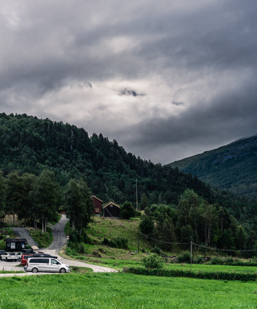 Cars parked at Innerdalen national park parking lot with the Trollheimen mountain range covered in white clouds on an overcast afternoon. More and Romsdal in Norwayの写真素材