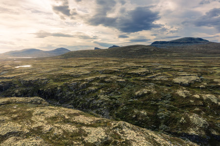 Breathtaking aerial view of the rugged terrain and gorge of Store RamshÃ¸gda in Rondane National Park under bright sunlight, natural beauty of Norwayの写真素材