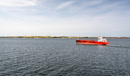 A chemical oil tanker sails through the Ãresund Strait, transporting goods between Denmark and Sweden. Calm waters and distant land create a serene backdropの写真素材