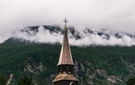 GjÃ¸ra Chapel tower stands tall in the village of GjÃ¸ra, surrounded by lush green mountains and soft clouds, showcasing its serene Norwegian landscape. In Sunndal, More and Romsdalの写真素材