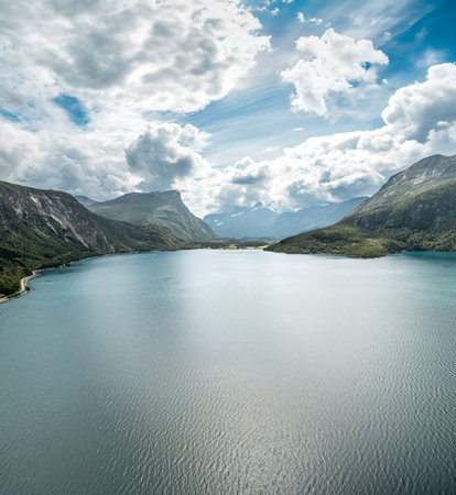 Drone captures Eresfjorden with the village of Eresfjord in Norway under a blue cloudy sky....