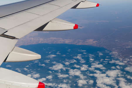 Clouds mountains and sky as seen through window of an aircraft of uzbekistanの写真素材