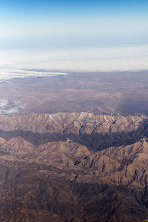 Clouds mountains and sky as seen through window of an aircraft of uzbekistanの写真素材