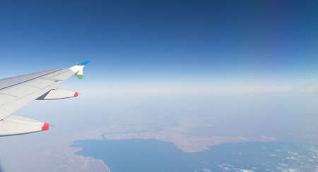 Clouds mountains and sky as seen through window of an aircraft of uzbekistanの写真素材