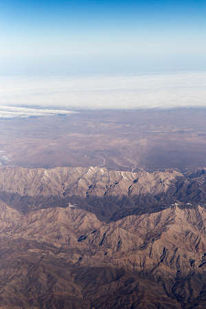 Clouds mountains and sky as seen through window of an aircraft of uzbekistanの写真素材