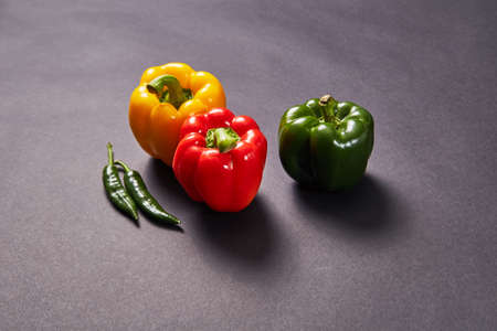 Red green yellow pepper in the kitchen black beautiful backgroundの写真素材