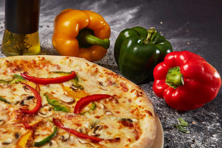 Red green yellow pepper in the kitchen black beautiful backgroundの写真素材
