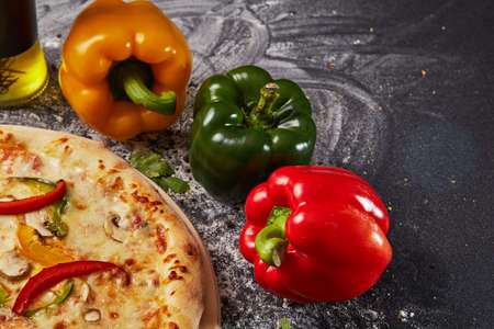Red green yellow pepper in the kitchen black beautiful backgroundの写真素材