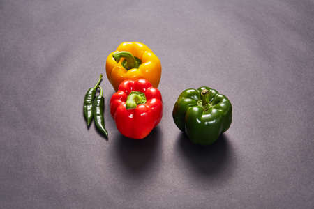 Red green yellow pepper in the kitchen black beautiful backgroundの写真素材