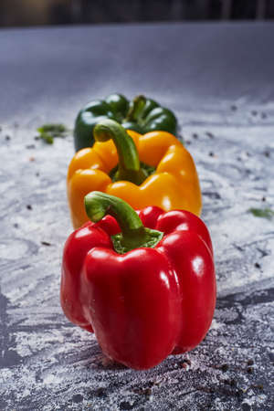Red green yellow pepper in the kitchen black beautiful backgroundの写真素材