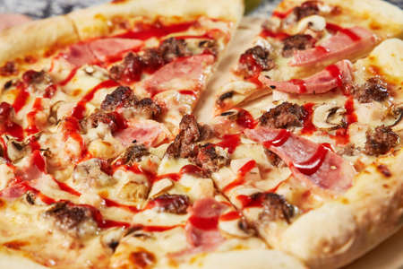 whole italian pizza on wood table with ingredients in black tableの写真素材