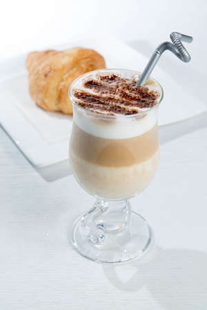 Glass of cold latte coffee topic cocolate cream on isolated white background with dessertsの写真素材