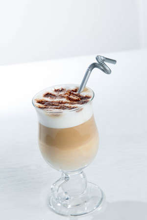 Glass of cold latte coffee topic cocolate cream on isolated white background with dessertsの写真素材