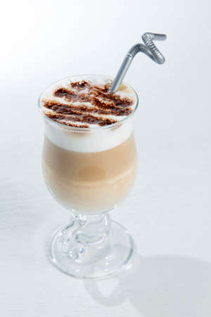 Glass of cold latte coffee topic cocolate cream on isolated white background with dessertsの写真素材